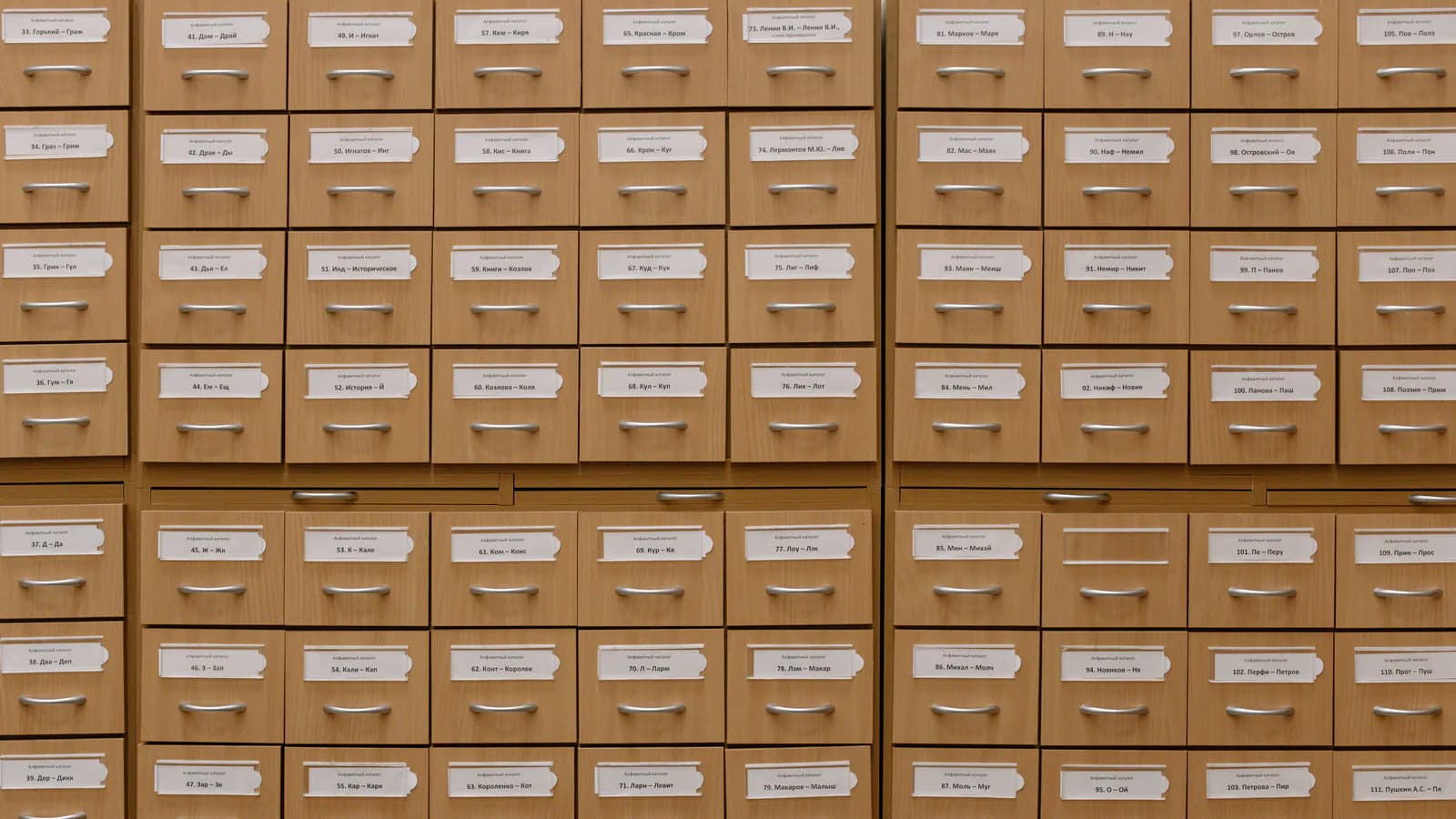 A wall of identical wooden catalogue drawers, every one carrying a numbered label and built to exactly the same shape.