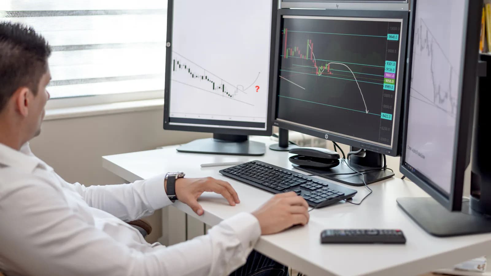 Several office monitors displaying live analytics dashboards side by side.