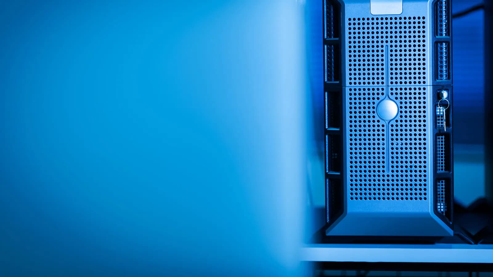 Rows of server racks in a data centre, the corridor lit in blue.