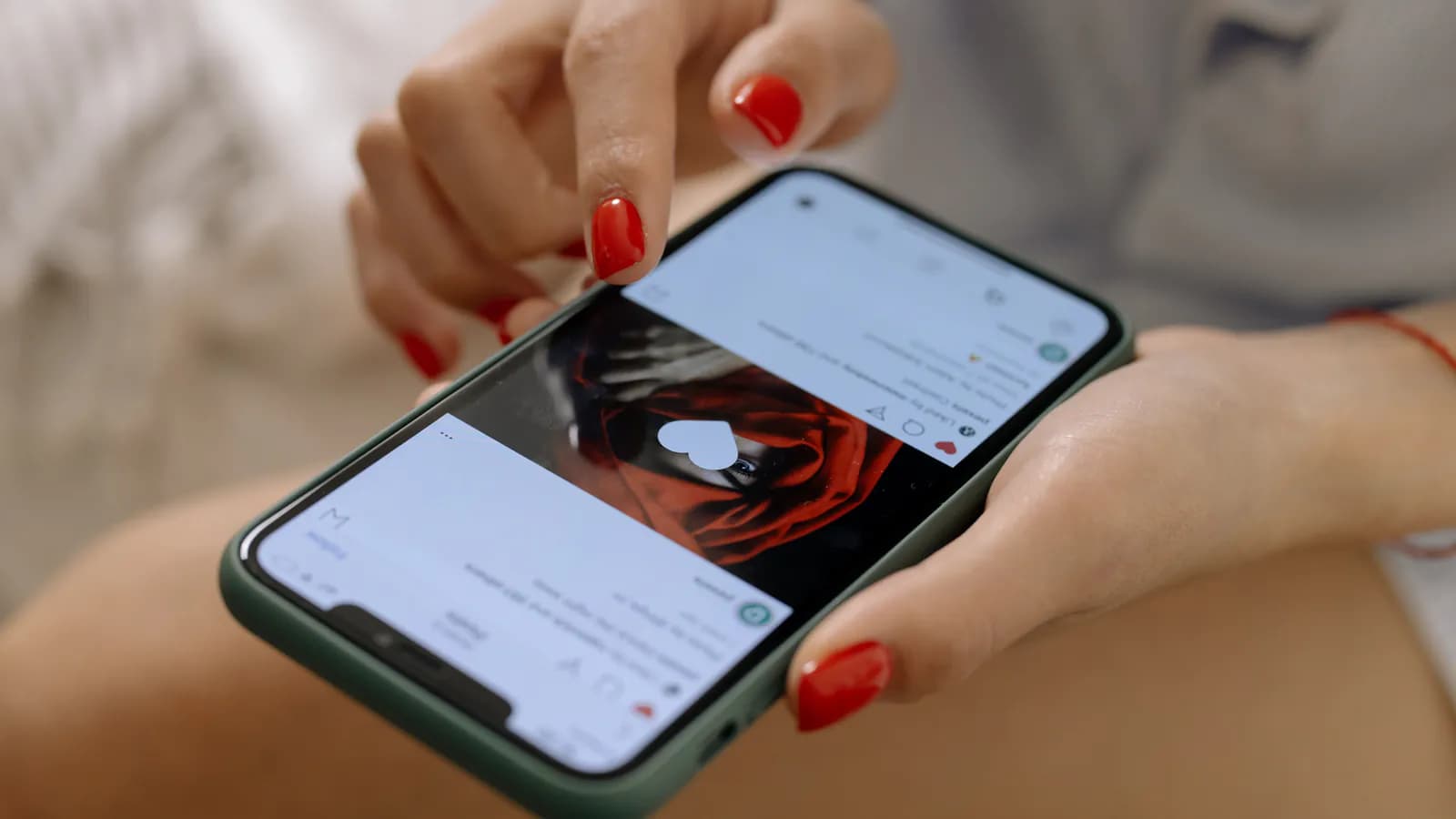 Рука держит смартфон и листает ленту Instagram, на экране одна за другой появляются квадратные фотокарточки.