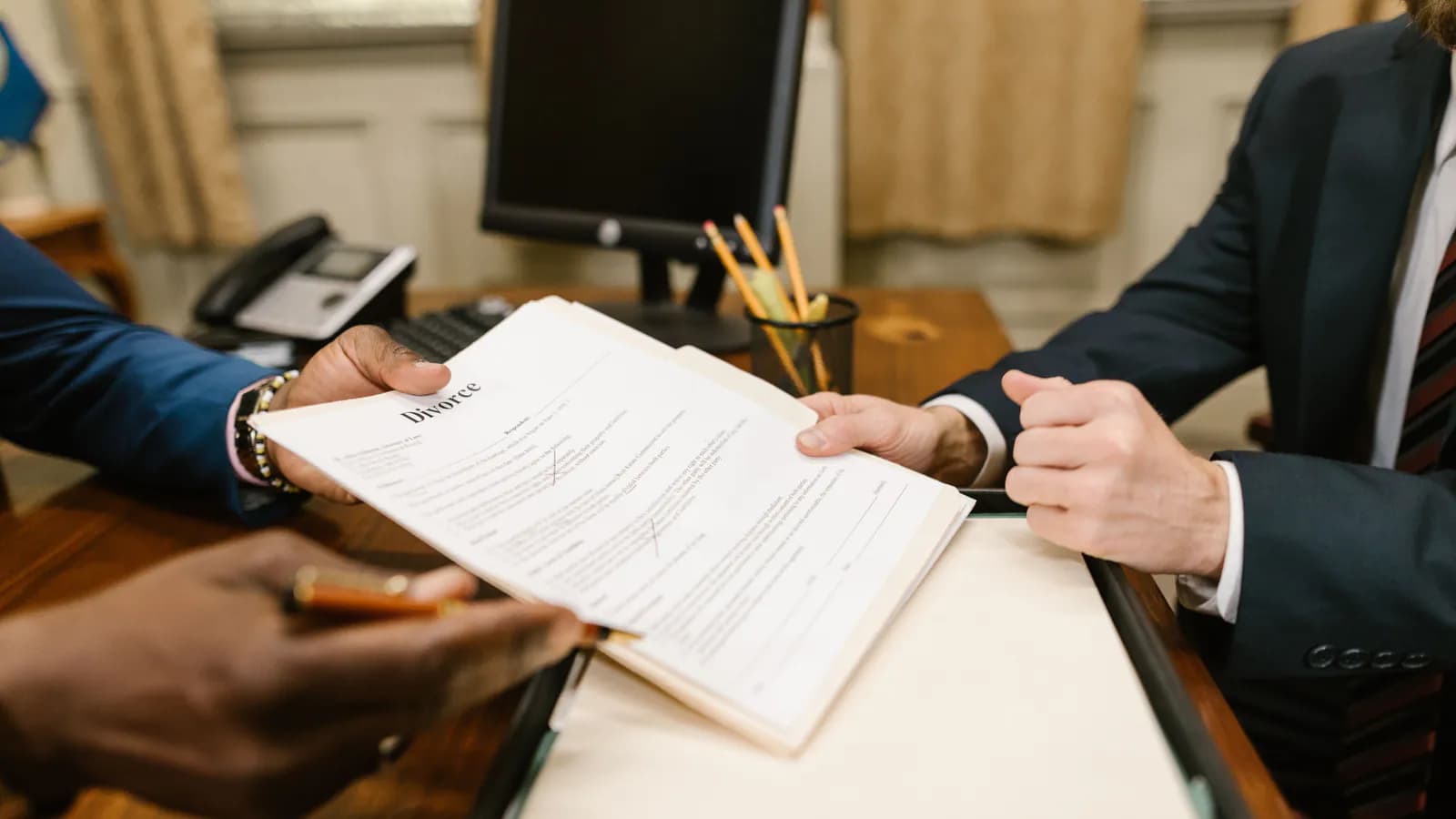 A contract document lying on a desk ready to be signed, with a pen and a cup of coffee beside it — the terms of an ad partnership on paper.