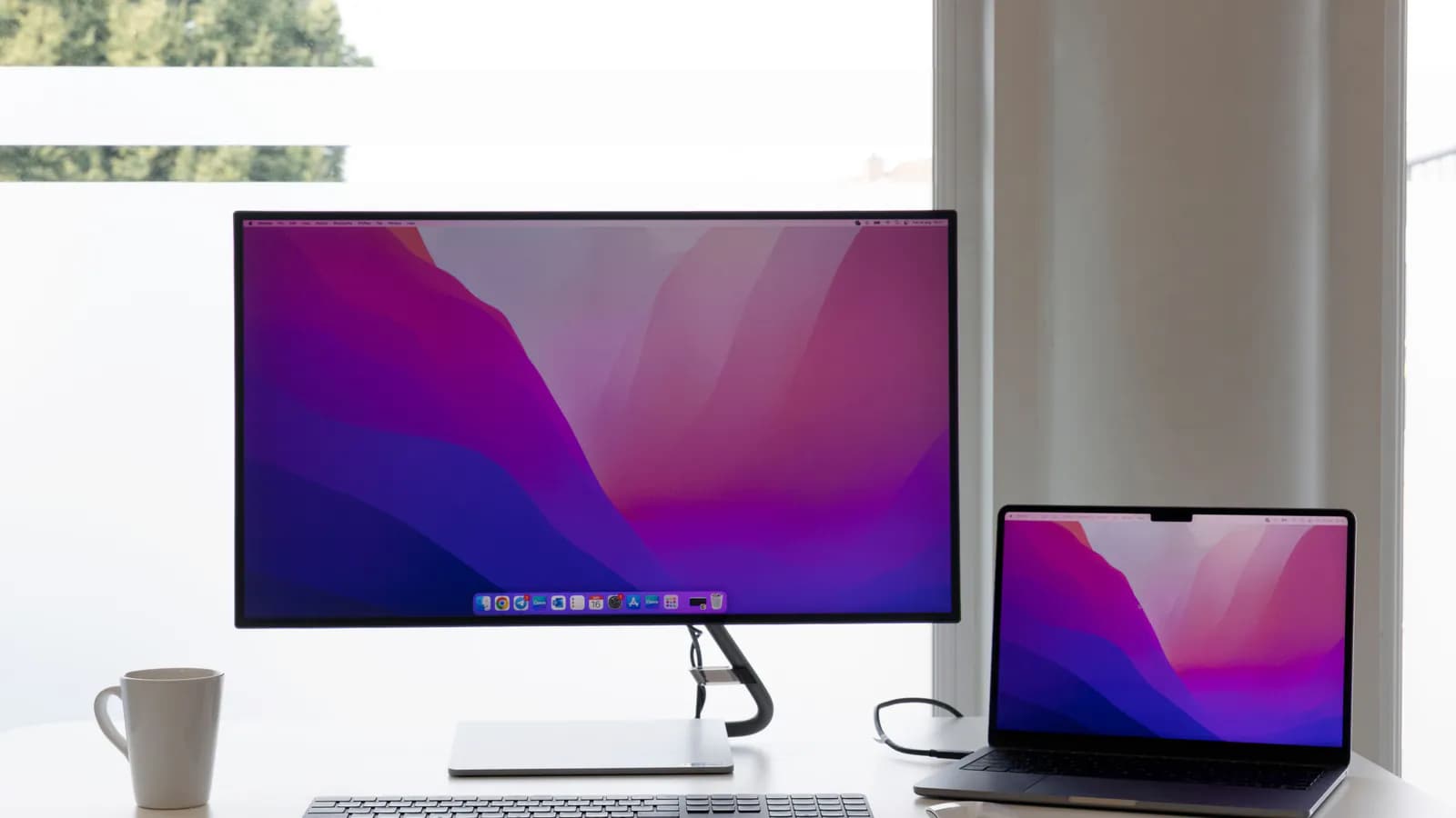 Two laptops open side by side, each screen showing the same section of a different website, lined up for comparison.